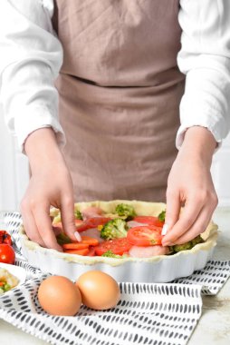 Mutfak masasında sebzeli tavuk turtası hazırlayan kadın, yakın plan.