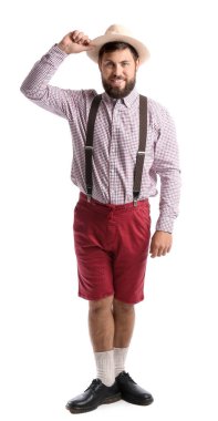 Beyaz arka planda geleneksel Alman kıyafetleri içinde yakışıklı bir adam.