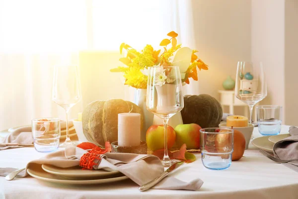 Yemek odasında balkabakları ve sonbahar yaprakları olan güzel bir masa.