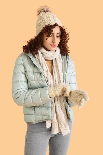 Frau Mit Strickmütze Zieht Handschuhe Auf Farbigem Hintergrund — Stockfoto