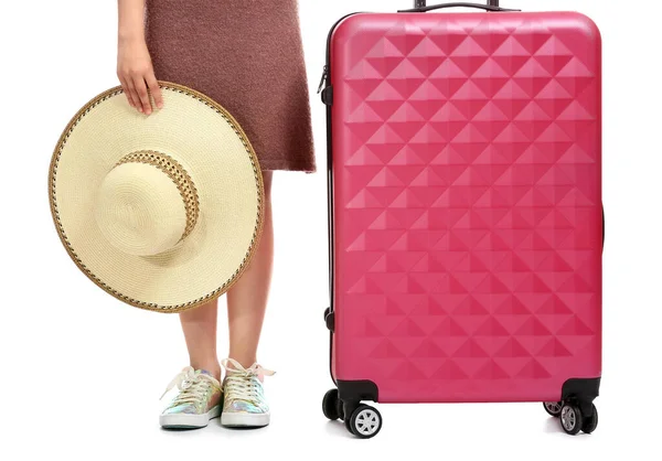 Beyaz arka planda bavulu ve şapkası olan sevimli küçük bir kız.