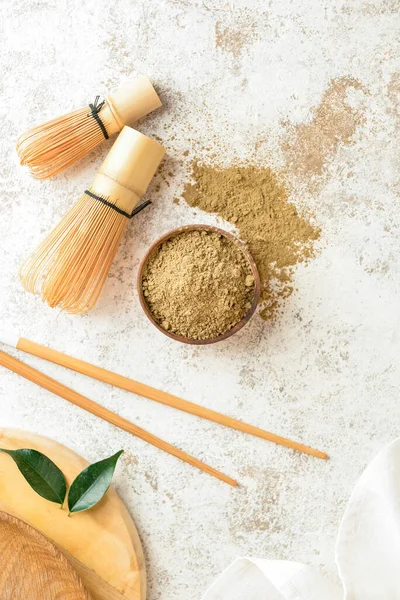 Hojicha pudralı kase ve açık arkaplanda chasen.