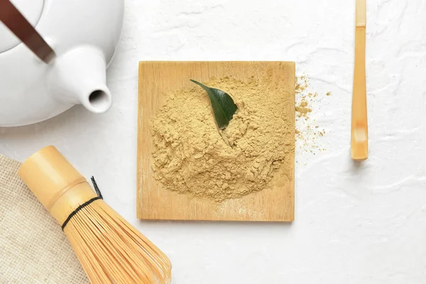 Beyaz arka planda hojicha tozu, chasen ve chashaku yığını