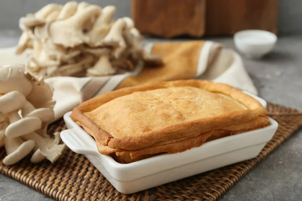 Arkaplanda lezzetli mantarlı turta pişirme.