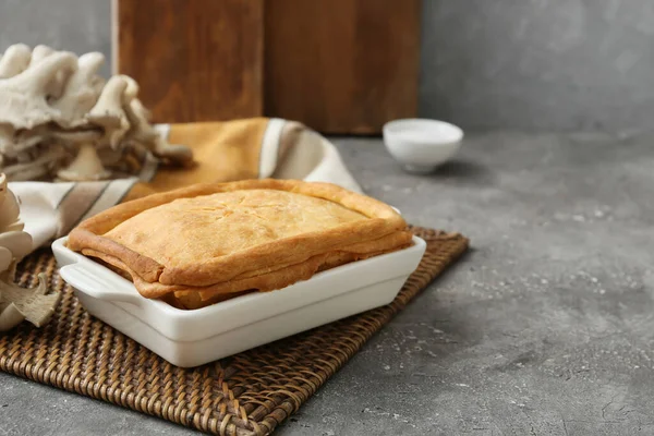 Arkaplanda lezzetli mantarlı turta pişirme.