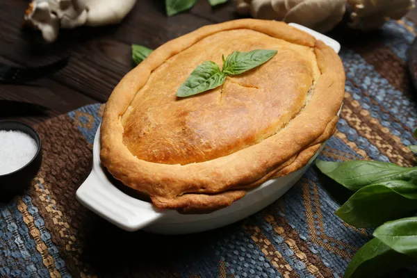 Siyah ahşap arka planda lezzetli mantarlı fırın yemeği.