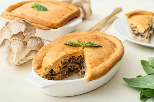 Beyaz ahşap arka planda lezzetli mantarlı yemek pişirmek.