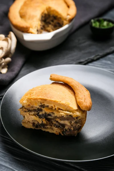 Siyah ahşap arka planda lezzetli mantarlı turta.