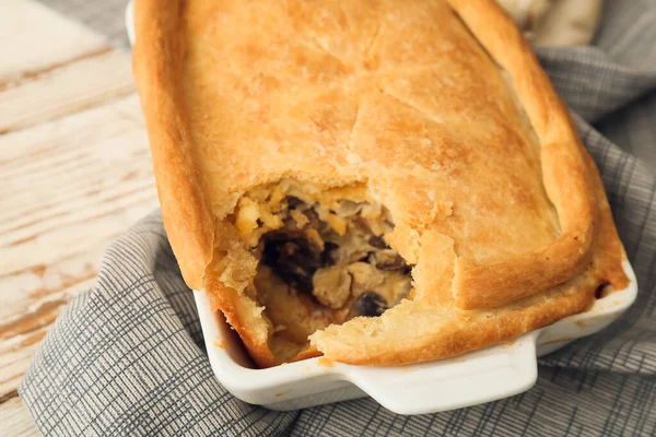 Beyaz ahşap arka planda lezzetli mantarlı fırın yemeği, yakın plan.