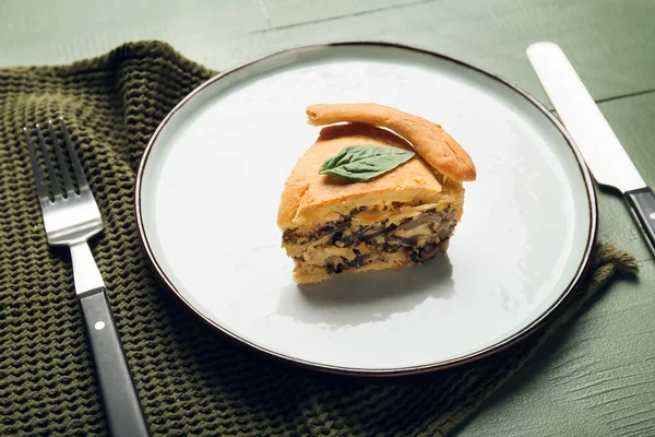 Yeşil ahşap arka planda lezzetli mantarlı turta.