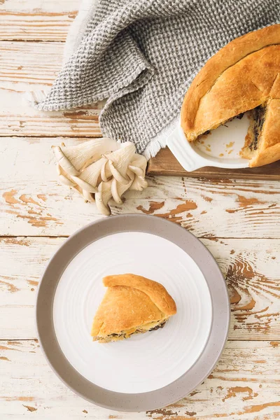 用白色木制背景的蘑菇锅馅饼烤盘子和盘子 — 图库照片