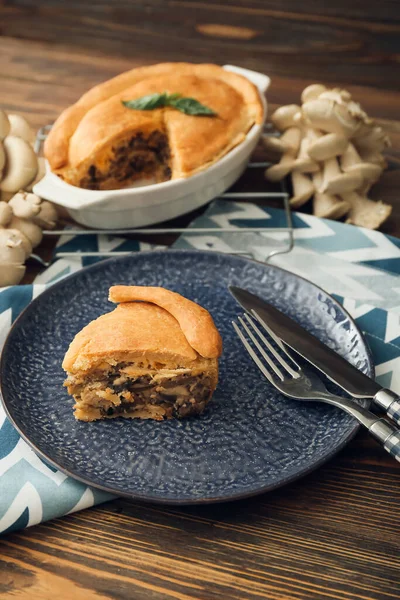 Ahşap zeminde lezzetli mantarlı turta tabağı.