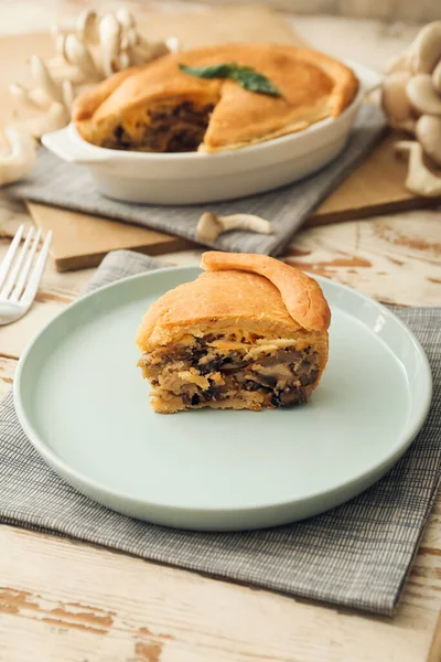 Beyaz ahşap arka planda lezzetli mantarlı turta.