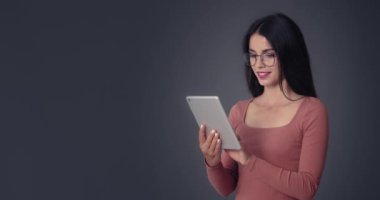Siyah arka planda tablet bilgisayarı olan genç bir kadın.
