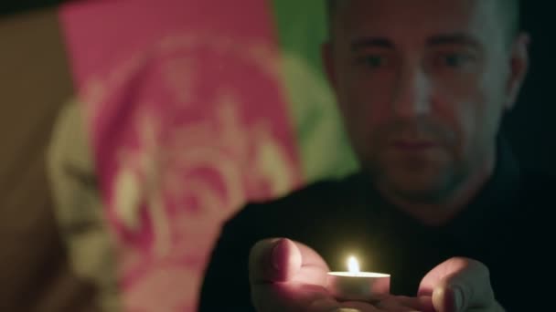 拿着燃烧的蜡烛对抗阿富汗国旗的人 — 图库视频影像