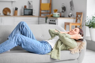 Evde müzik dinleyen güzel genç bir kadın.