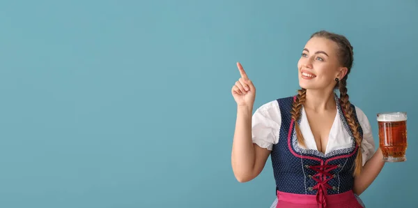 Mladá Servírka Oktoberfestu Pivem Ukazuje Něco Modrém Pozadí Prostorem Pro — Stock fotografie