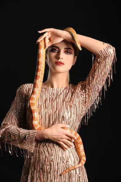 セクシーな若いです女性とともにヘビ上の黒背景 — ストック写真