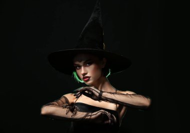 Karanlık arka planda örümceği olan genç cadı