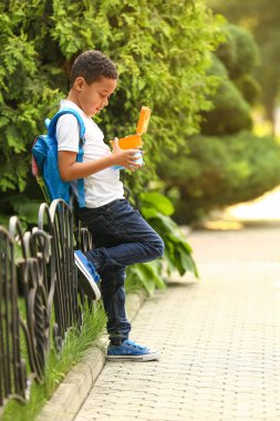 Dışarıda öğle yemeği yiyen şirin bir çocuk.