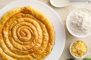 Hafif arka planda lezzetli ıspanaklı turta kompozisyonu, yakın plan.