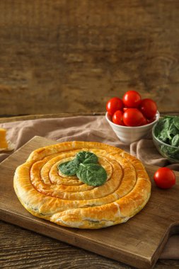 Ahşap zemin üzerinde lezzetli ıspanaklı turta olan tahta.