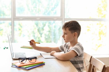 Evde internetten ders alan küçük bir çocuk.