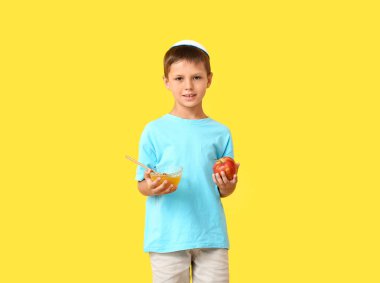 Arkaplanda bal ve elma olan küçük bir çocuk. Rosh Hashanah (Yahudi Yeni Yılı) kutlaması