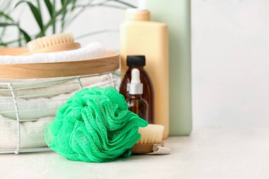 Yeşil sünger ve banyo malzemeleri masada, yakın plan.
