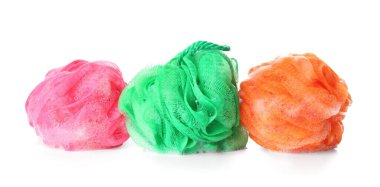 Beyaz arka planda köpüklü farklı banyo süngerleri.