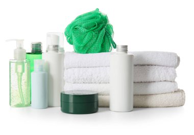 Beyaz arka planda sünger ve havluyla banyo malzemeleri.