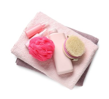Beyaz arka planda havlular, kozmetik ürünler, sünger ve masaj fırçası