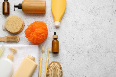 Hafif arka planda banyo malzemeleri ve turuncu sünger seti, yakın plan.