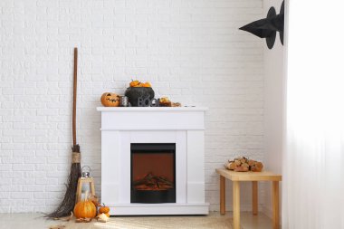 Beyaz tuğla duvarın yanında Cadılar Bayramı dekorlu modern şömine