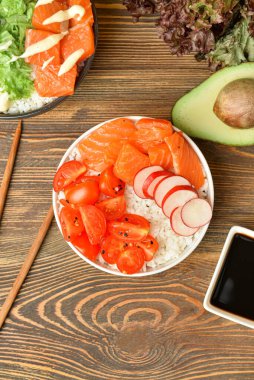 Somon, sebze ve ahşap arka planda sos dolu lezzetli kaseler.