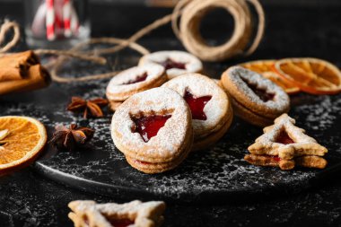 Koyu arkaplanda lezzetli Linzer kurabiyeleri olan tahta, yakın plan.