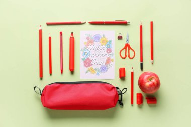 Öğretmenler Günü kavramı. Okul malzemeleri ve tebrik kartı. Renkli arka plan, üst görünüm.