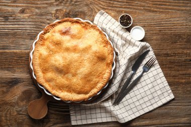 Ahşap arka planda lezzetli tavuklu turta pişirme tabağı