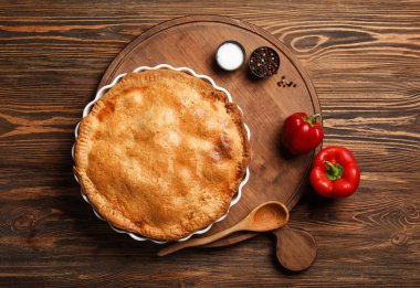 Ahşap arka planda lezzetli tavuklu turta pişirme tabağı