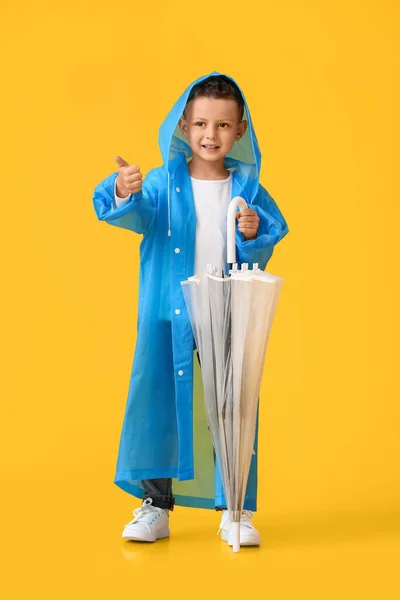 Roztomilý Chlapeček Pláštěnce Deštníkem Ukazující Palec Nahoru Barevném Pozadí — Stock fotografie