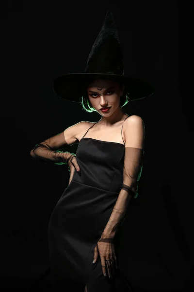 美しい女性は 暗い背景にハロウィーンの魔女に扮した — ストック写真