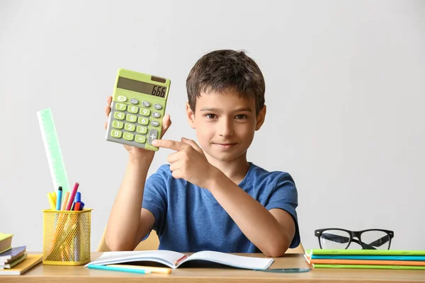 Kleine Jongen Met Rekenmachine Doen Huiswerk Aan Tafel Lichte Achtergrond — Stockfoto