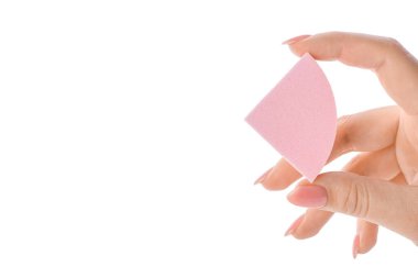 Beyaz arka planda şık makyaj süngeri olan kadın eli.