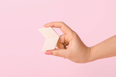 Arka planda makyaj süngeri olan kadın eli