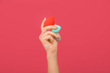 Renkli makyaj süngerleri olan kadın eli