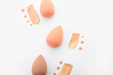 Beyaz arkaplanda şık makyaj süngerleri ve temel örnekleri