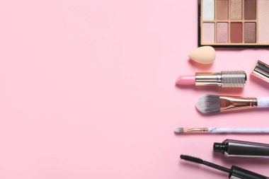 Renkli arka planda şık makyaj süngerleri ve dekoratif kozmetikler