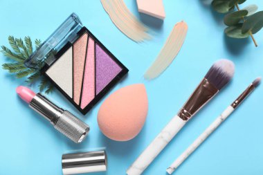 Renkli arka planda şık makyaj süngerleri ve dekoratif kozmetikler
