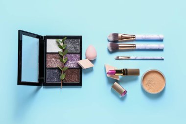 Renkli arka planda şık makyaj süngerleri ve dekoratif kozmetikler