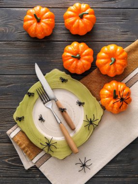 Karanlık ahşap arka planda örümcekler ve balkabaklarıyla Cadılar Bayramı sofrası